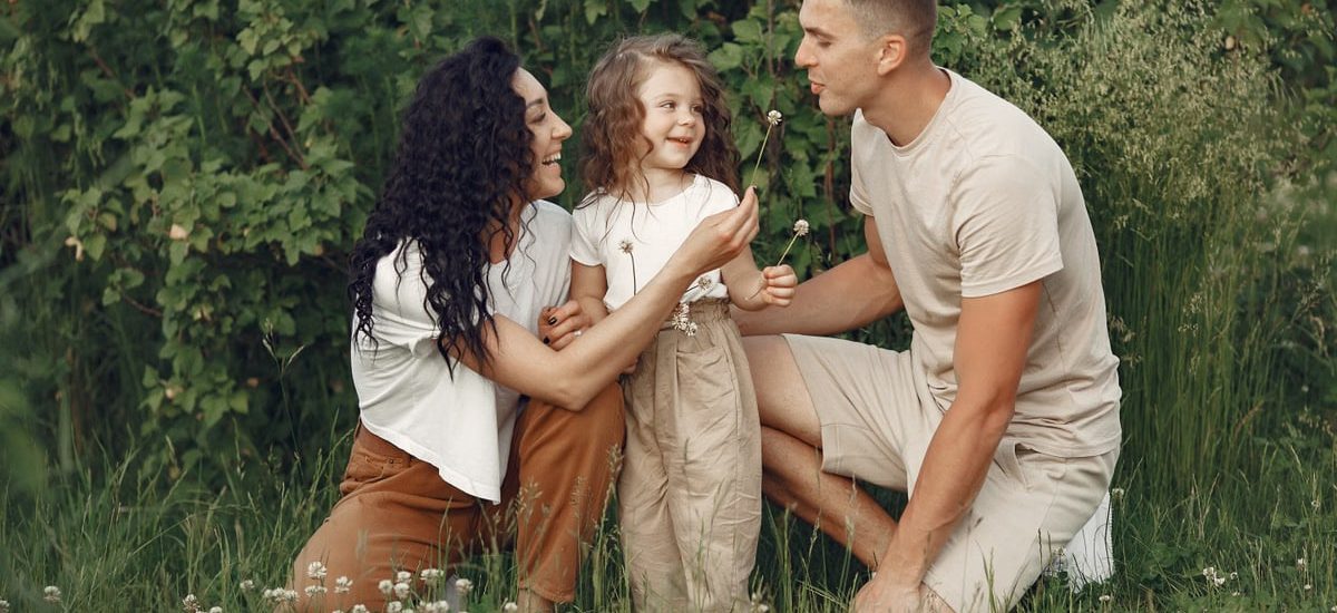 A joyful family enjoying time together in a lush green meadow, capturing love and bonding.