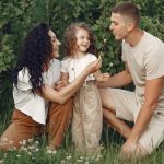 A joyful family enjoying time together in a lush green meadow, capturing love and bonding.