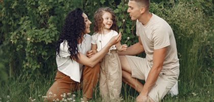A joyful family enjoying time together in a lush green meadow, capturing love and bonding.