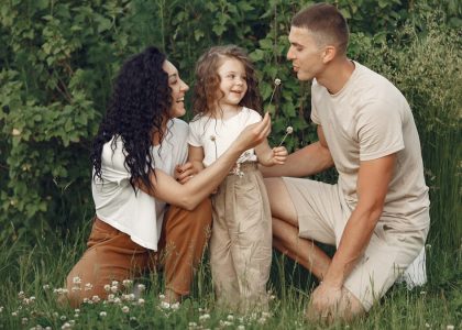 A joyful family enjoying time together in a lush green meadow, capturing love and bonding.